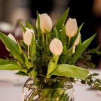 餐桌上漂亮的中间装饰品，白色的鲜花和蜡烛